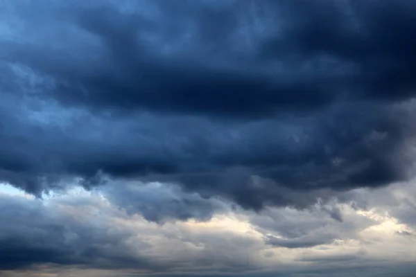 Storm sky covered with dark cumulus clouds before the rain. Dark cloudy sky, overcast day, beautiful dramatic background for stormy weather