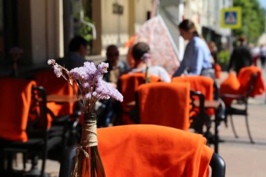 Sokak kafesi, açık bir restoranda boş masalar. Yaz şehrinde romantik akşam yemeği, ziyaretçiler ve garsonlar, kutlama ve tarih için zarif bir ortam