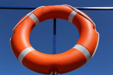 Turuncu lifebuoy bir gemi tahtasında. Su güvenliği, kurtarma, mavi gökyüzü arka plan üzerinde yaşam halkası