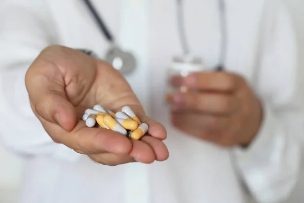 Hap ile doktor, kapsül ile şişe ilaç veren hekim. İlaçların doz kavramı, vitaminler, tıbbi reçete, eczane, grip tedavisi