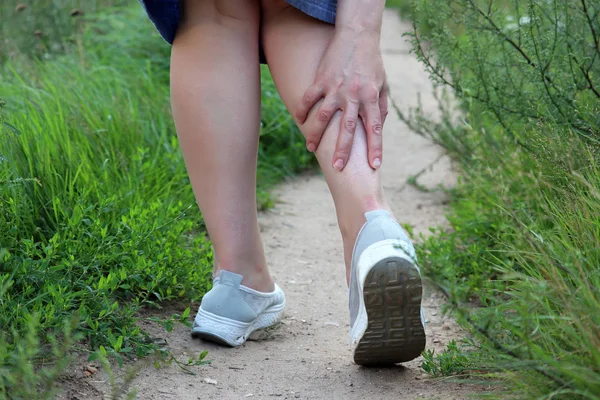 脚踝扭伤 女人抓住她的腿 而走在夏天的性质 疲劳腿部疼痛 跑步时受伤的概念 — 图库照片