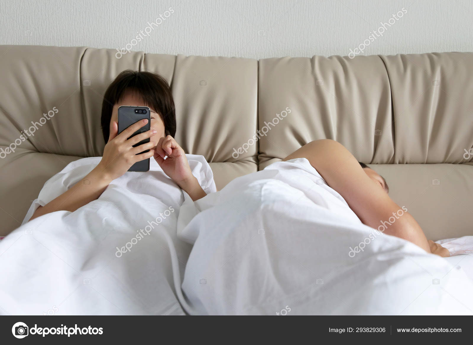 Wife Using Smartphone Bed Texting While Her Husband Sleeping