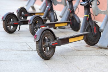 Elektrikli scooter'lar sokağa park etmiş. Çevre dostu ulaşım, kiralama sistemi, otoparkta e-scooter