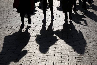 Sokaktaki insanların siluetleri ve gölgeleri. Kaldırımda yürüyen kalabalık, sosyal sorunlar, nüfus ve toplum kavramı