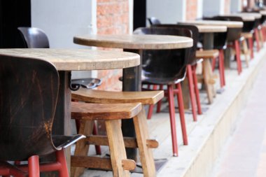 Sokak kafesi, boş masalar ve açık bir restoranda eski ahşap sandalyeler. Koronavirüs salgını sırasında şehir işleri