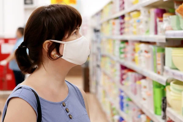 Kvinna Medicinsk Mask Ett Köpcentrum Bakgrunden Hyllor Med Varor Begreppet — Stockfoto