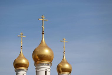 Mavi gökyüzüne karşı Ortodoks Kilisesi 'nin haçları olan üç altın kubbe. Hristiyan tapınağı, inanç kavramı