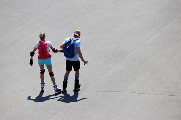 カップルのローラースケートの通りの手を保持し 上のビューに乗って 都市での夏のレジャー 健康的なライフスタイル — ストック写真