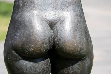 Female butt of metal statue close-up. Sculpture of woman with sexy body