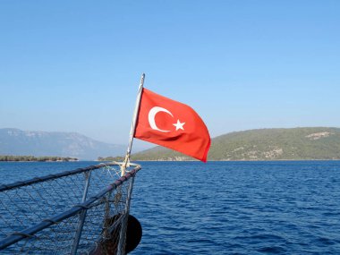 Geminin burnunda hindi bayrağı, seyahat konsepti. Yazın Türk kıyıları, adalı Akdeniz manzaralı