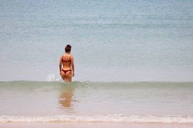 Bikinili kadın denizde yüzecek. Tropikal kumsalda plaj tatili, yaz tatili