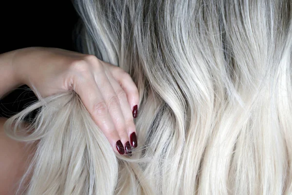 Mulher Loira Com Manicure Vermelho Endireita Seu Cabelo Encaracolado Longo — Fotografia de Stock