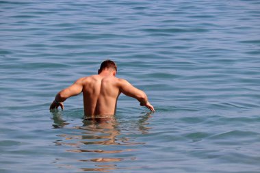 Adam denizde yüzmeye gidiyor. Plaj tatili ve su tatili.