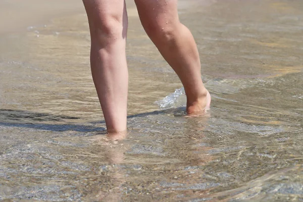 裸足の女性は海の波の中で砂の上を歩く サーフウォーター ビーチバケーションで裸の女性の足 — ストック写真