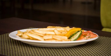 Biber, domates ve salatalık bir tabak kızarmış patates