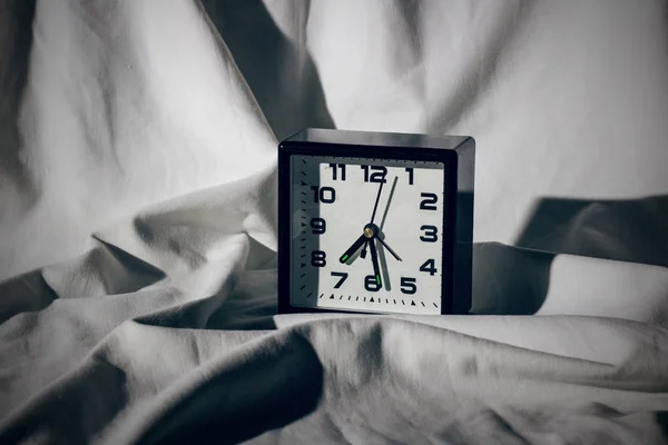 Black Alarm Clock White Sheet Hard Shadows Sleeping — Stock Photo, Image