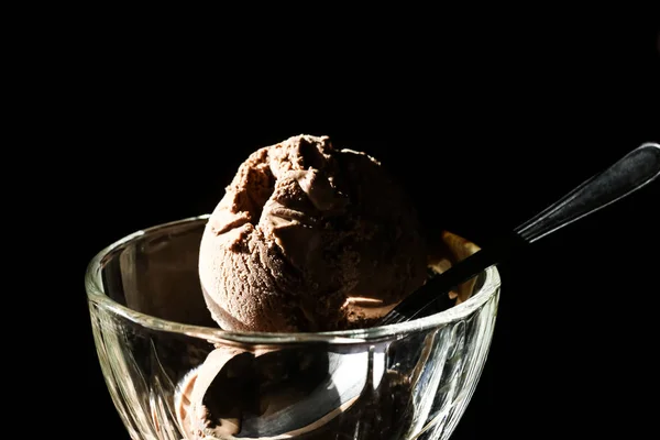 Chocolate ice cream in a cup on a black background