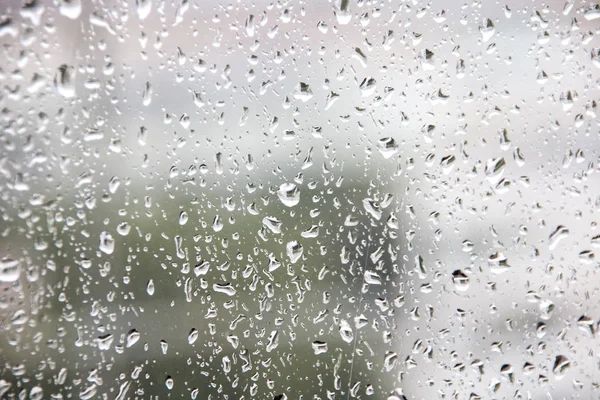 城市背景下的玻璃上落下的雨滴 — 图库照片