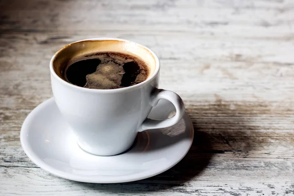 Bir fincan kahve ve bir ahşap beyaz masa üzerinde bir daire