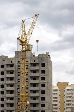 Bir bulutlu gökyüzü arka plan üzerinde yüksek inşaat İnşaat Vinç