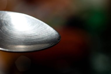 Boş metal çay kaşığı yeşil bir arka plan üzerinde kapat