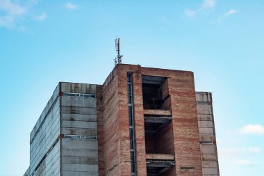 Mavi gökyüzüne karşı çok öykülü bir binanın çatısında yetenekli bağlantı pilonlar
