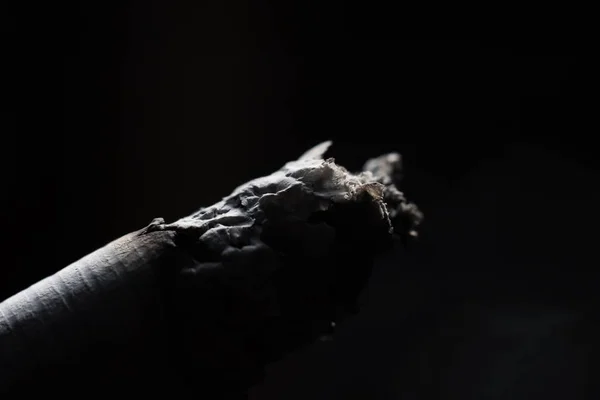 Пепел на сигарете крупным планом в темноте — стоковое фото