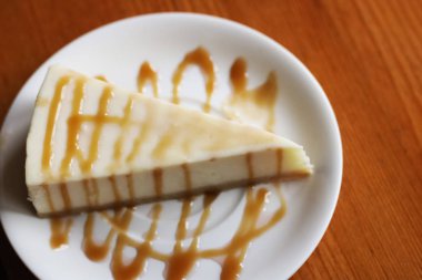 Cheesecake karamel ile ahşap bir masa üzerinde kapat