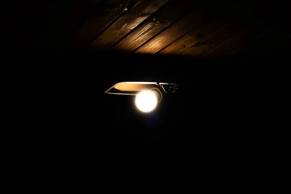 Vecchia lampada su un soffitto di legno al buio — Foto Stock