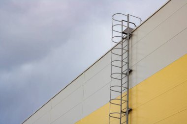 Bir karanlık gökyüzü arka plan üzerinde uzun boylu bir binanın çatı merdiveni