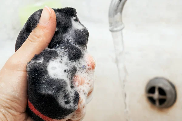 Black washcloth with foam in hand close up — Stock Photo, Image