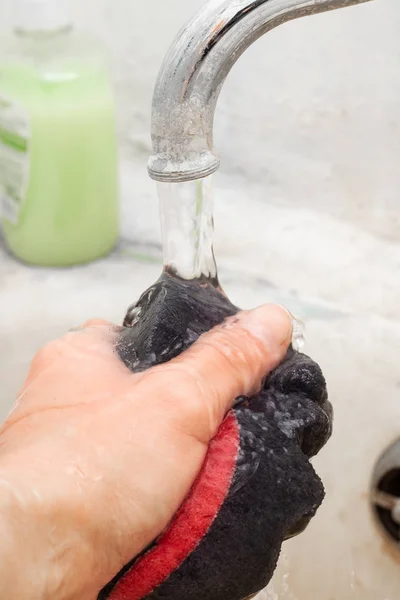 Black washcloth with foam in hand close up — Stock Photo, Image