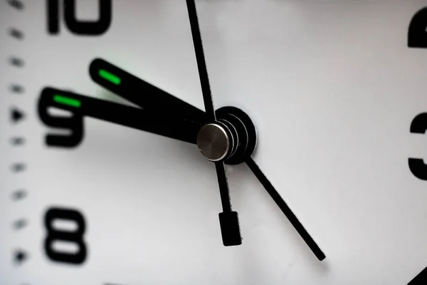 Schwarze Zeiger einer Uhr auf weißem Zifferblatt in Nahaufnahme — Stockfoto