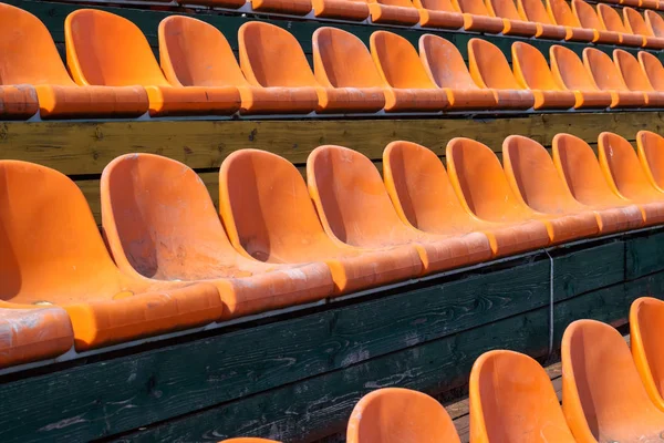 A lot of orange plastic seats close up, background and texture