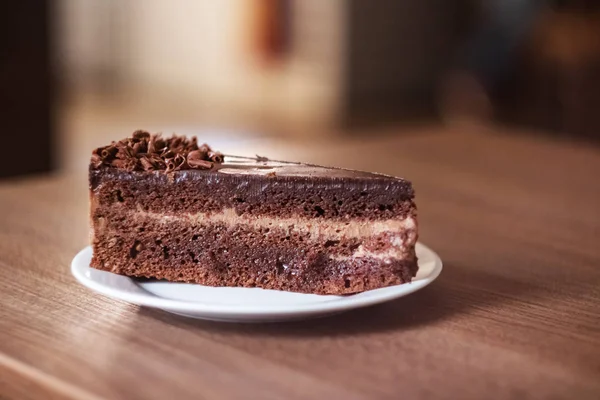 木桌上白盘上的巧克力蛋糕特写 — 图库照片