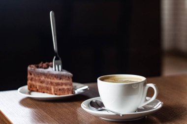 Bir tabak ve bir fincan kahve yakın çikolatalı kek