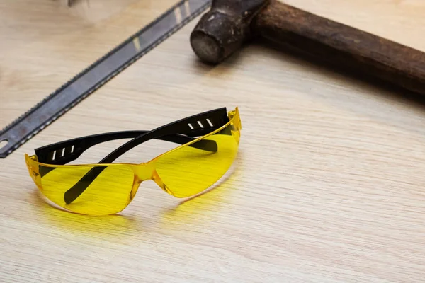 Żółte Okulary Ochronne Narzędzia Drewnianym Stole Bliska — Zdjęcie stockowe