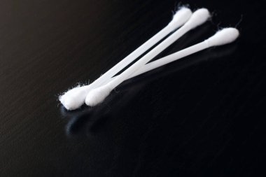 Siyah ahşap bir masa üzerinde üç pamuk tomurcukları