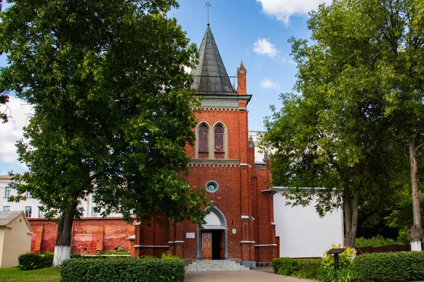 Antigua iglesia de ladrillo rojo entre árboles verdes en Polotsk —  Fotos de Stock