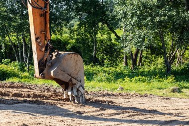 Sarı kum üzerinde ekskavatör kova yakın