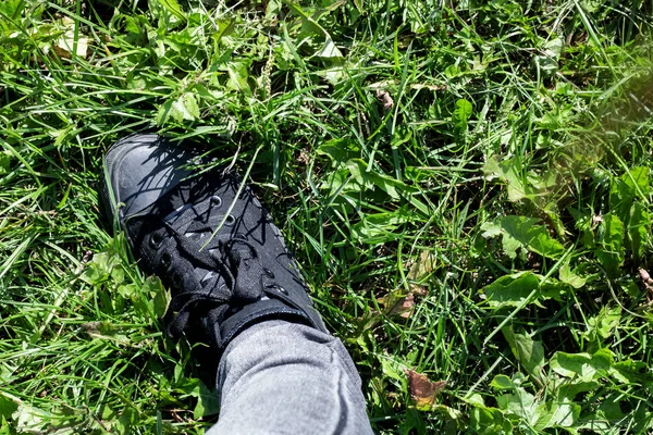 Pied dans une botte noire sur l'herbe — Photo