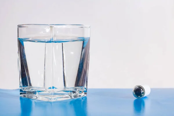 Capsule with camera for capsular endoscopy and glass of water — Stock Photo, Image