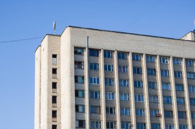 Mavi gökyüzünün arka planında uzun bir evin pencereleri