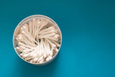 Mavi bir masa closeup üzerinde bir bardak pamuk tomurcukları