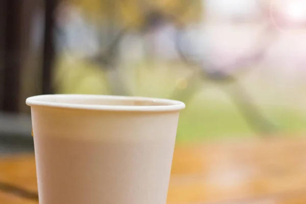 Weiße Papiertasse mit Kaffee auf einem Holztisch — Stockfoto