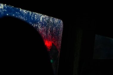 Geceleri yağmur damlalarıyla dolu bir arabanın yan camı