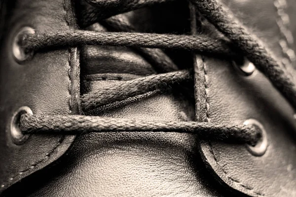 Kanten op zwarte mannen laarzen close-up — Stockfoto