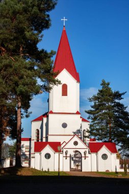 Belarus, Novopolotsk - 16 Ekim 2019: Ağaçlar arasında haç olan kırmızı çatı