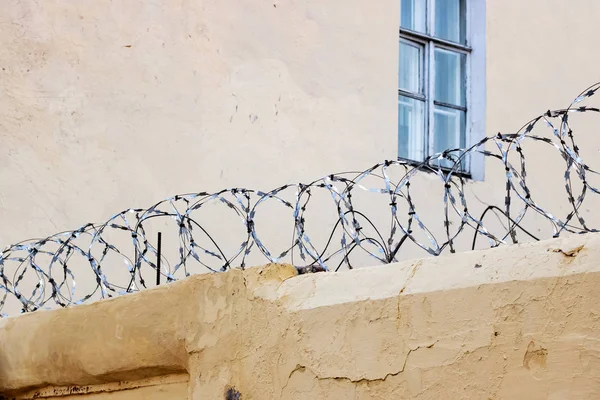 Колюча сітка на бетонному паркані в'язниці — стокове фото