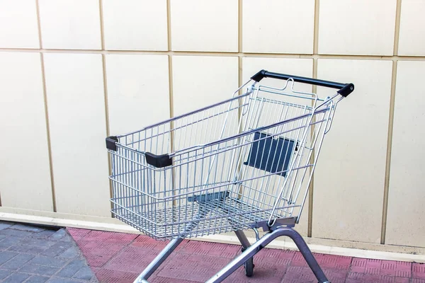 食料品のための空のショッピングトロリーは壁で閉じます — ストック写真